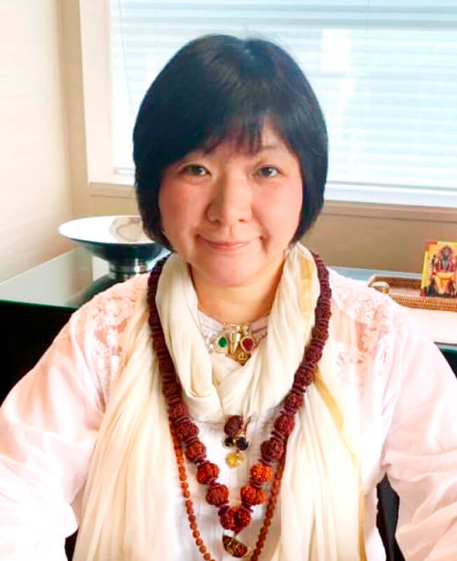 鑑定講師Jyotish KIMIの写真。温かい表情で座っている様子。